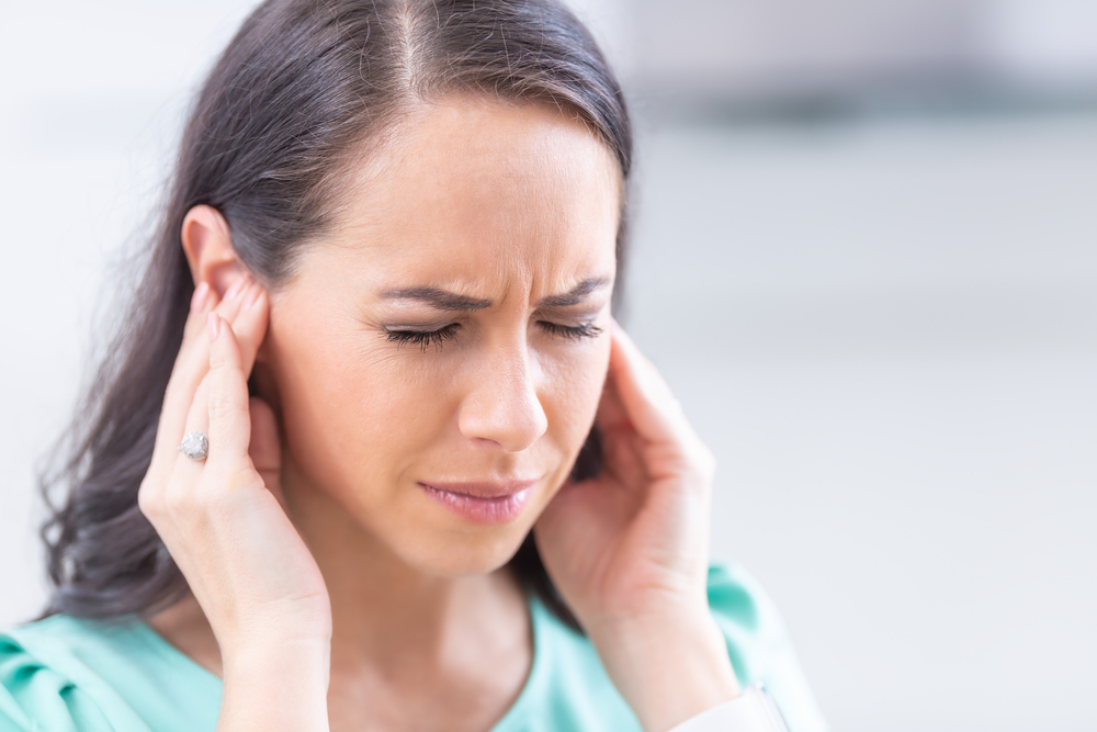 Woman experiencing discomfort inside the ears, types of hearing loss